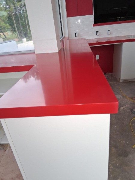Glossy red solid surface countertop and peninsula.